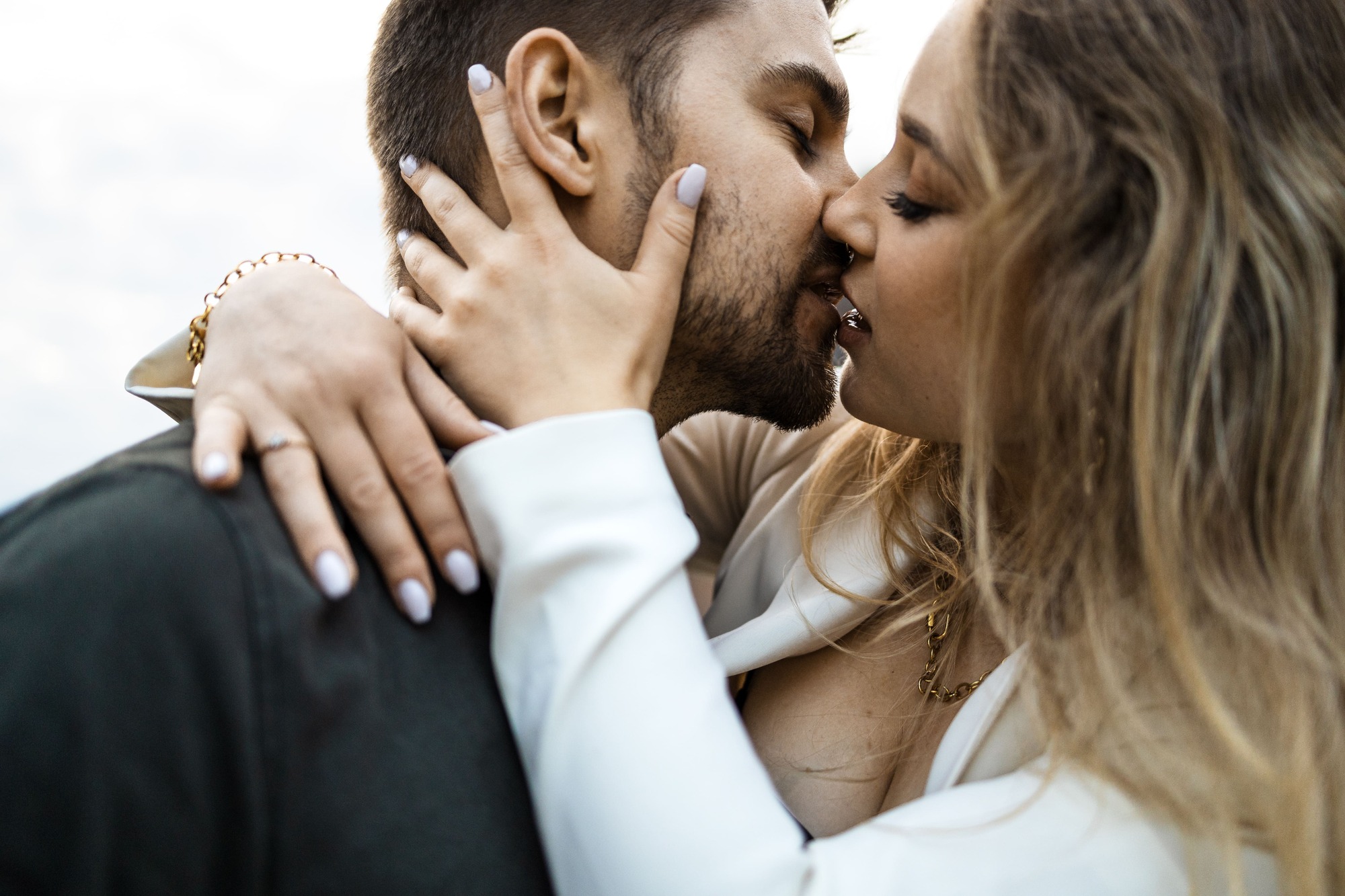 Junges Brautpaar kuesst sich heiss und innig